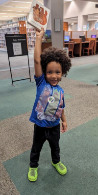 Child holding a book aloft